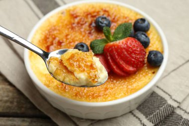 Böğürtlenli ve nane şekerli nefis creme brulee 'yi ahşap masadan alıp, yakın plan