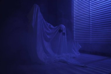 Ürkütücü hayalet. Pencerenin yanında, mavi ışıkla kaplanmış kadın.