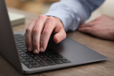 E-öğrenme. Çevrimiçi ders sırasında masadaki bilgisayarı kullanan adam, yakın plan.