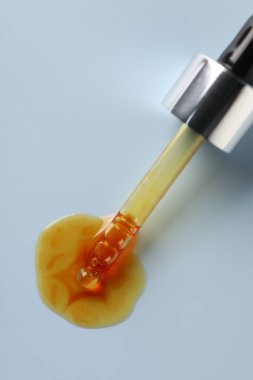 Açık gri arka planda boru ve nemlendirici serum, üst görünüm