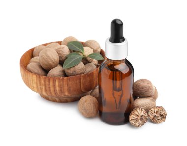 Nutmeg temel yağı, fındık ve yaprakları beyazın üzerinde izole edilmiş.