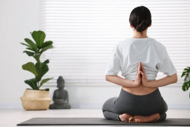 Yoga stüdyosunda arkasında namaste ile vajinanı prova eden bir kız.
