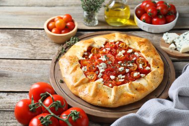 Ahşap masa üzerinde domates, kekik ve peynirli lezzetli galet (Caprese galette), yakın çekim