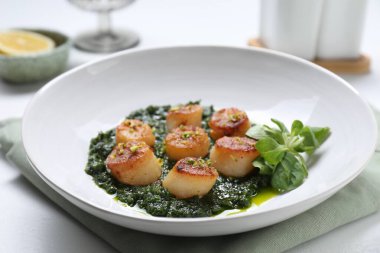 Lezzetli soslu leziz kızarmış deniz tarakları ve beyaz masada mısır salatası, yakın plan.