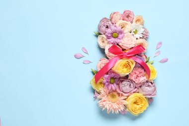 8 Mart tebrik kartı tasarımı açık mavi arka planda güzel çiçeklerle yapıldı, üst manzara. Metin için boşluk