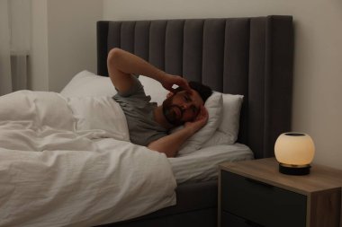 Geceleri yatakta baş ağrısı çeken bir adam