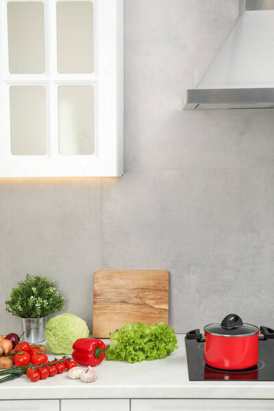 Cooking dinner. Pot and fresh vegetables on countertop in kitchen