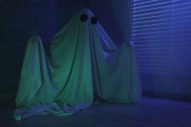 Ürkütücü hayalet. Pencerenin yanında, mavi ışıkla kaplanmış kadın.