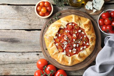 Tahta masa üzerinde domates ve peynirli (Caprese galette) leziz galette düz bir bileşim yatıyordu. Metin için boşluk