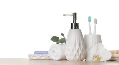 Banyo aksesuarları. Farklı kişisel bakım ürünleri ve beyaz arka plana karşı ahşap masadaki çiçek. Metin için boşluk