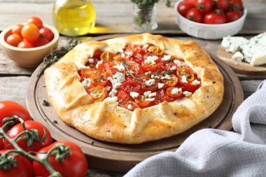 Ahşap masa üzerinde domates, kekik ve peynirli lezzetli galet (Caprese galette), yakın çekim