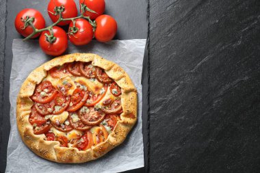 Koyu dokulu masa üzerinde domates ve peynirli (Caprese galette) leziz bir galet. Metin için boşluk