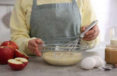 Gri masada yumurta çırpan kadın, yakın plan.