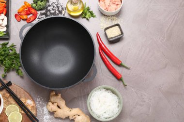 Wok, çubuklar ve gri desenli masa üzerinde farklı ürünler, düz yatak. Metin için boşluk
