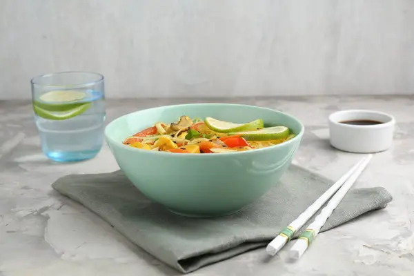 搅拌油炸 将鸡肉和蔬菜放在碗里 放在灰色质构桌子上食用的美味熟面 — 图库照片