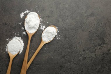 Gri desenli masa üzerinde kaşık içinde kabartma tozu. Metin için boşluk