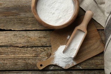 Kabın içinde kabartma tozu ve tahta masanın üstünde kepçe. Metin için boşluk