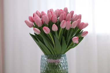 İçerideki vazoda pembe laleler.