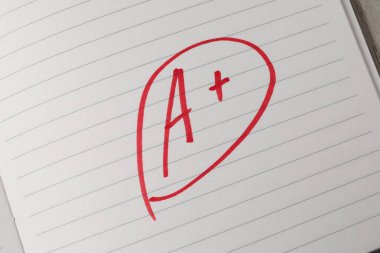 Okul derecesi. Not defteri kağıdında artı işareti olan kırmızı harf A, üst görünüm