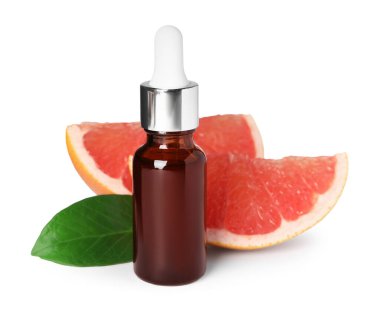 İçinde greyfurt yağı, yaprak ve beyaz üzerine izole edilmiş taze meyve parçaları olan bir şişe.