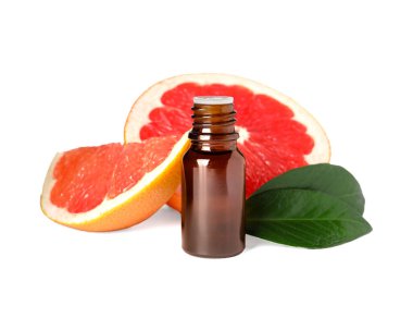 Bir şişe greyfurt yağı, yapraklar ve beyaz üzerine izole edilmiş taze meyve.