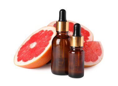 Greyfurtlu şişeler temel yağ ve beyaz üzerine izole edilmiş taze meyve parçaları.