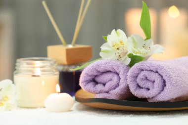 Beyaz havluyla farklı spa ürünleri ve çiçeklerin bulunduğu güzel kompozisyon bulanık arka plan, yakın plan