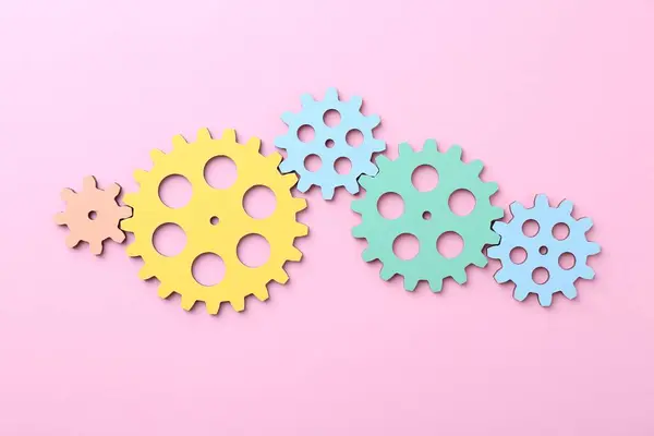 Business process organization and optimization. Scheme with colorful figures on pink background, top view