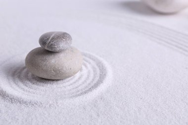 Beyaz kumdaki Zen bahçe taşları desenli, metin için boşluk
