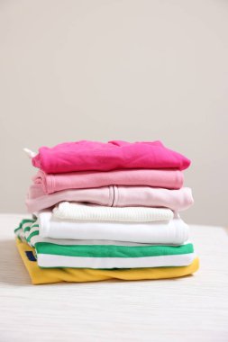 Bej arkaplana karşı katlanmış kıyafet yığını