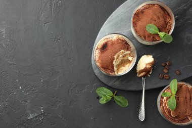 Bardakta, kaşıkta, nane yapraklarında ve kahve çekirdeklerinde nefis tiramisu. Metin için boşluk