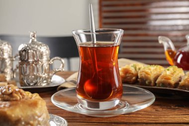 Türk çayı ve tatlıları ahşap masa üzerindeki antika çay setinde servis edilir.