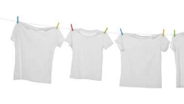 Çamaşır ipinde kuruyan birçok tişört beyaza izole edilmiş.
