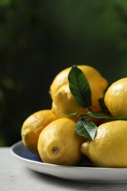 Açık havada taze limonlar ve yeşil yapraklar.