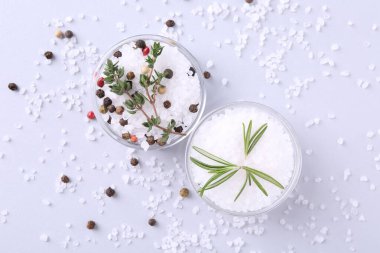 Biber taneli tuz, kekik ve biberiye tabakta ışık masasında, düz yerde.