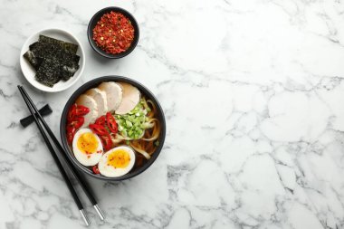 Beyaz mermer masada servis edilen ramen tabağındaki leziz ramen, yazı için yeri olan bemol. Erişte çorbası.