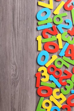 Ahşap okul masasında renkli numaralar, düz yatış. Metin için boşluk