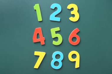 Yeşil zemin üzerinde renkli sayılar, düz yatıyordu