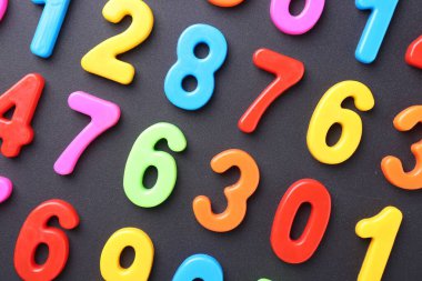 Koyu gri arkaplanda renkli sayılar, düz yatış