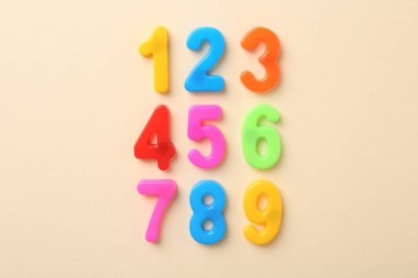 Bej arkaplanda renkli sayılar, düz yatış