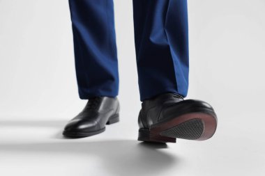 Beyaz arka planda deri ayakkabılı iş adamı, yakın plan.