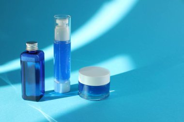 Açık mavi arka planda lüks kozmetik ürünleri. Metin için boşluk