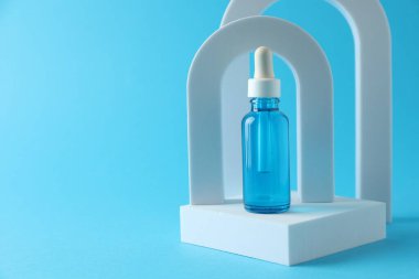 Açık mavi arkaplanda serumun şık sunumu. Metin için boşluk