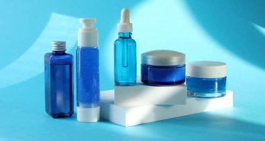 Açık mavi arka planda lüks kozmetik ürünleri.