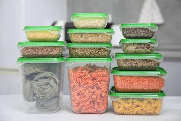 Plastic containers filled with food products on light table indoors