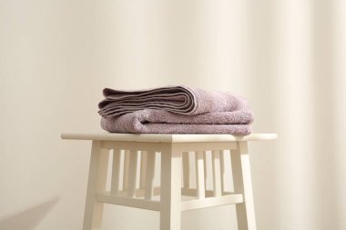 Beyaz duvara karşı menekşe havlular.