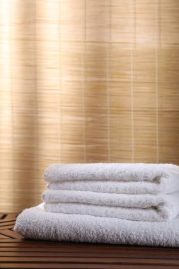 İçerideki ahşap masaya yığılmış yumuşak havlular.