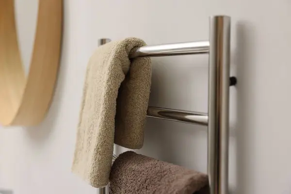 Heated towel rail with towels in bathroom, closeup