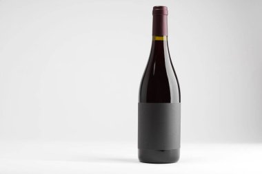 Beyaz zemin üzerinde bir şişe lezzetli kırmızı şarap, metin için boşluk