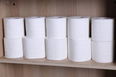 Ahşap rafta istiflenmiş tuvalet kağıdı ruloları